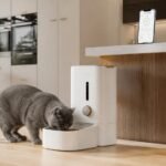 Smart microchip cat feeder and health tracking app in a luxury modern kitchen